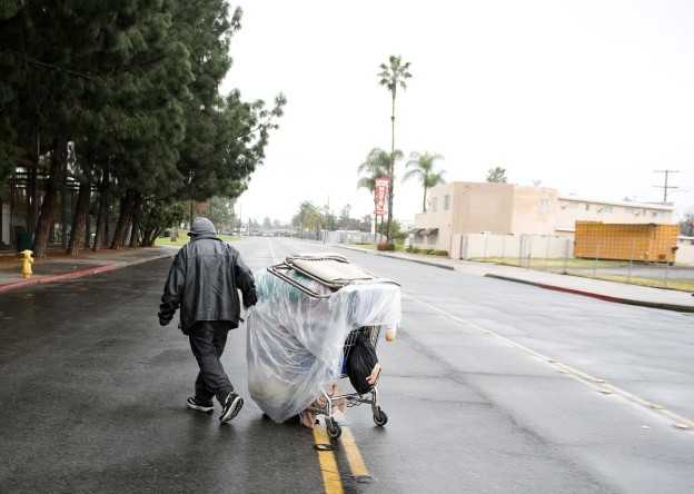 A homeless man moves his belongings to La Palma Park in Anaheim after taking down his tent of tarps he used to sleep in Friday night. Teams of volunteers descended on all parts of the county early Saturday morning to count and interview as many people as they could in areas where homeless individuals are known to congregate. ////ADDITIONAL INFO: - 07_homelesscount.0126.ks. - Day: Saturday - Date: 1/26/13 - Time: 7:30:25 AM - Original file name _KSB1455.NEF - KEN STEINHARDT, ORANGE COUNTY REGISTER -- This is the biannual Point in Time Count and Survey of the Homeless, which is mandated by the U.S. Department of Housnig and Urban Development in order for the county to quality for $16 million in Federal Continuum of Care funding for homeless services. *(EDITOR'S NOTE)* -- Contact John Viafora Orange County Housing and Community Development Manager, (714) 480-2820